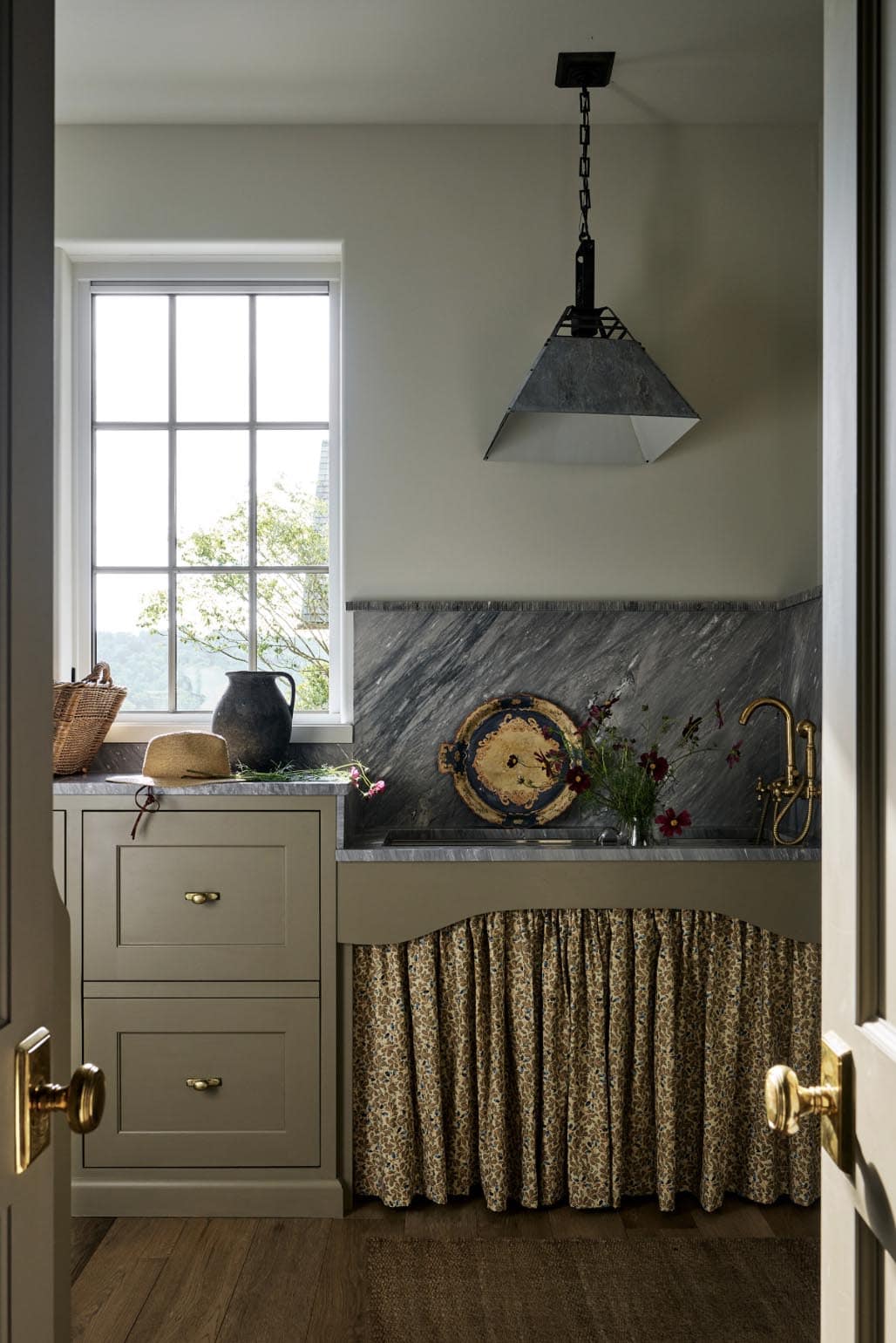 Skirted sink nook with soapstone backsplash and galvanized pendant light