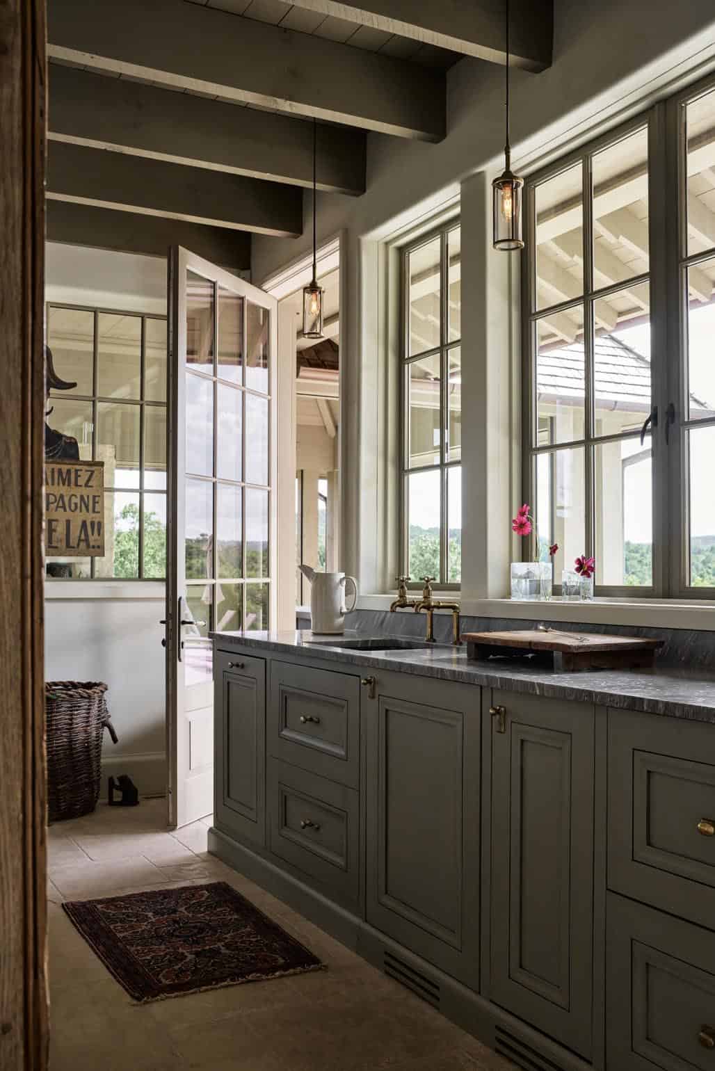 Beamed prep kitchen with brass bridge faucet and mountain view windows