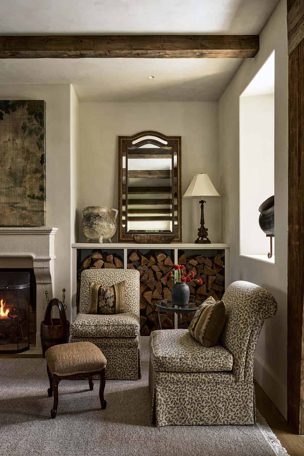 Leopard print armchairs beside stacked firewood nook and stone fireplace