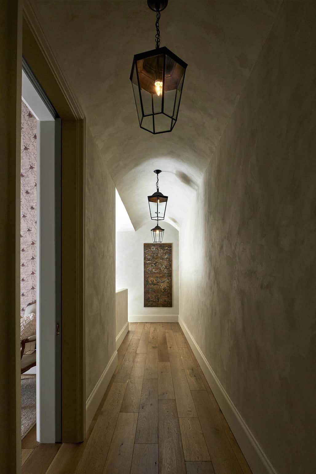Barrel vaulted hallway lined with hanging lantern pendant lights