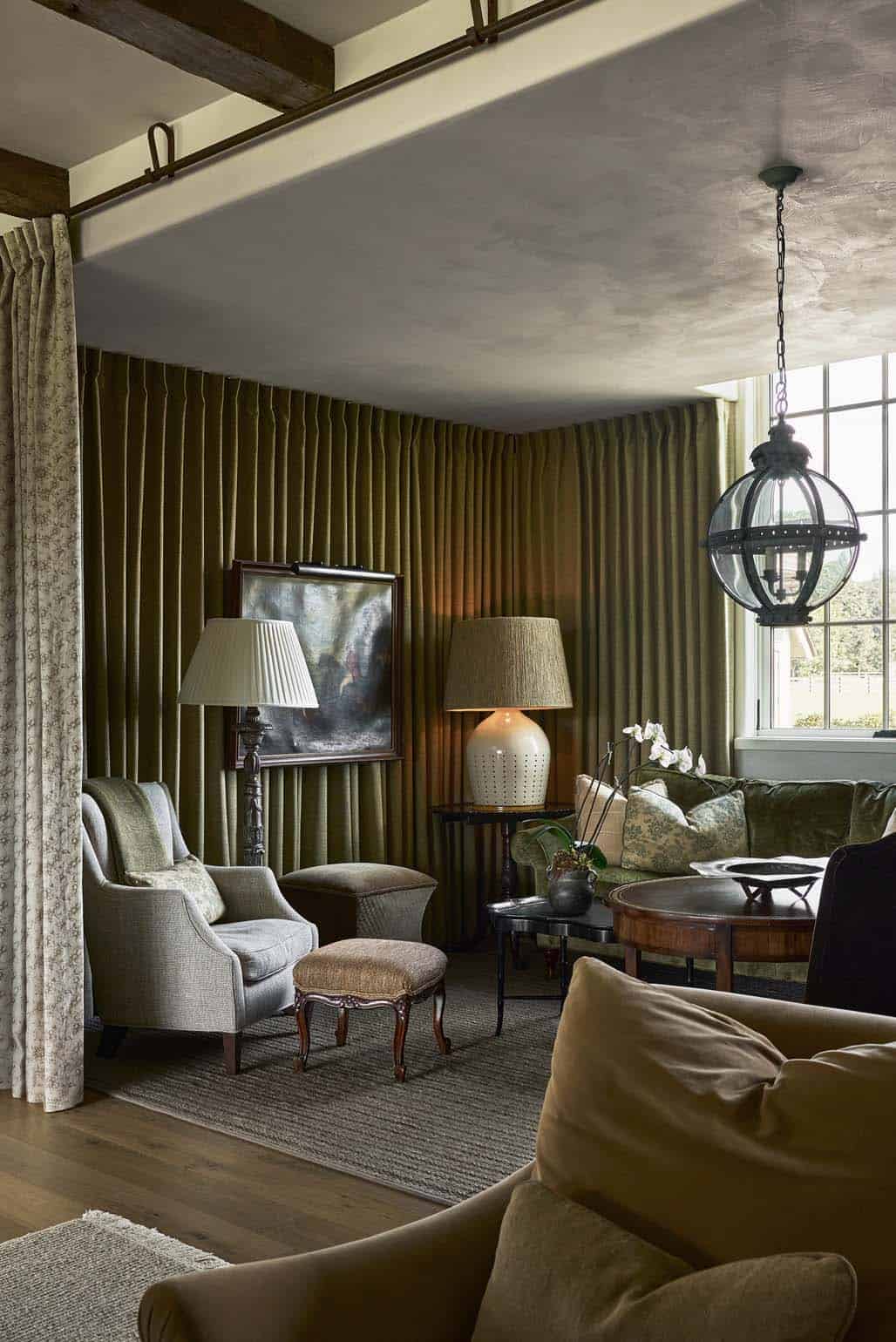 Olive velvet drapery lounge with layered lamps and antique oil painting