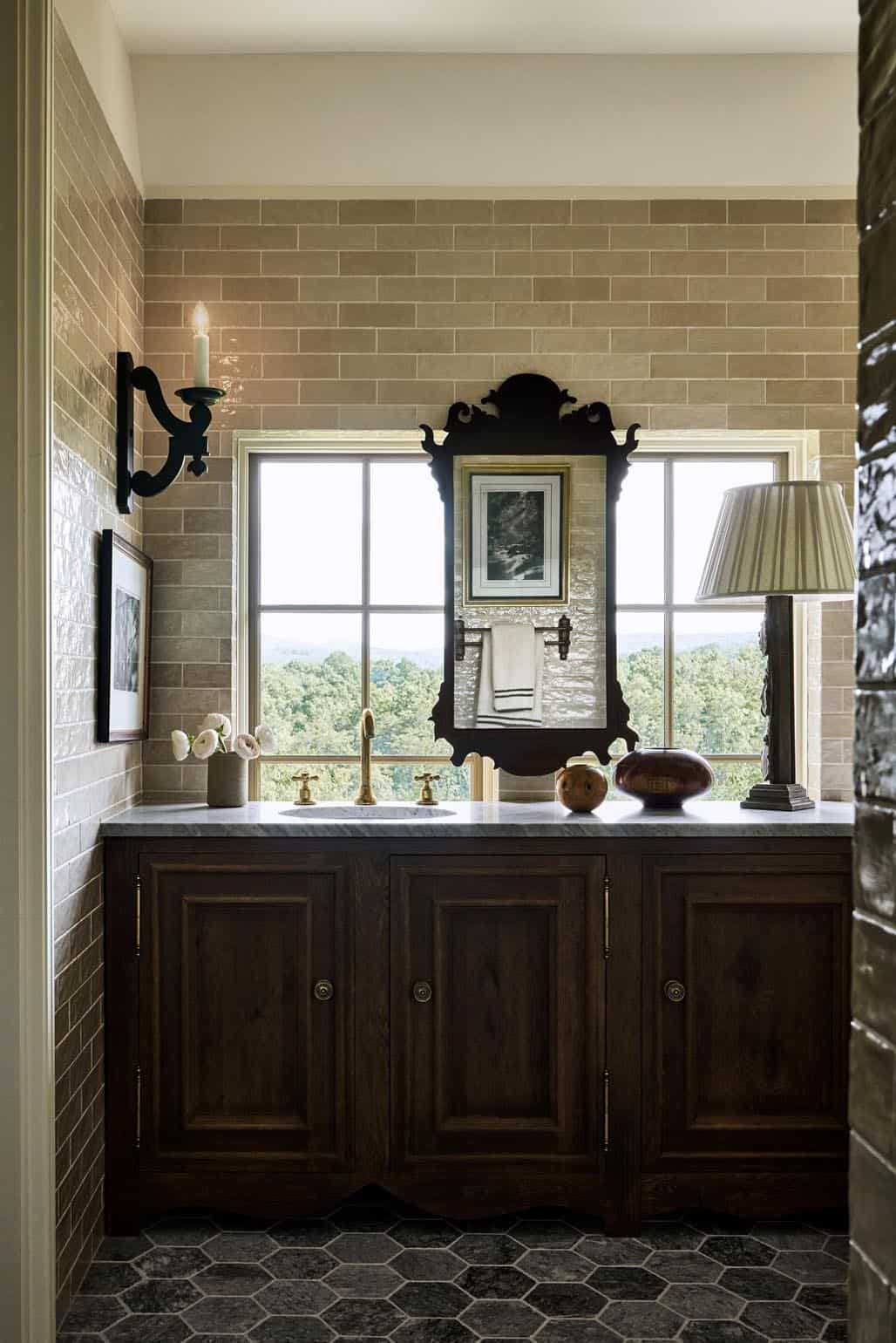 Powder room vanity with ornate mirror and glazed subway tile walls