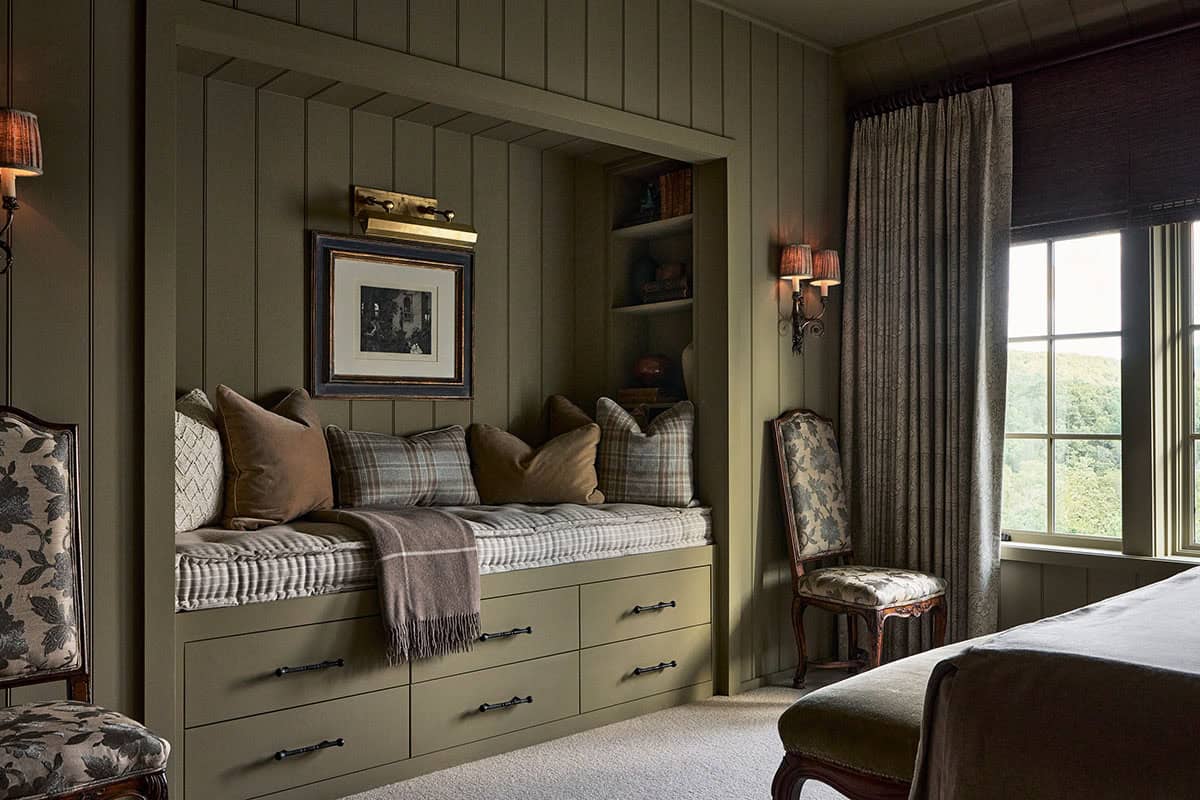 Built in window seat nook with plaid pillows and wall sconces