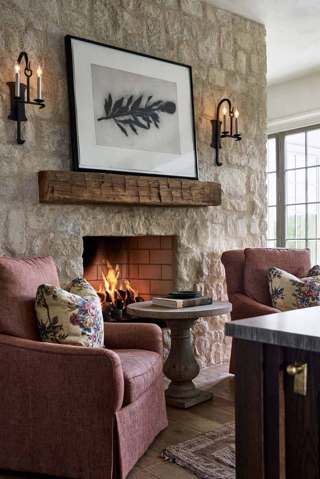 Botanical print above reclaimed wood mantel flanked by candle sconces