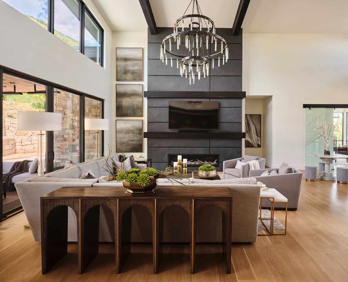 Living room with dark tiled fireplace wall, mounted TV, and gray sectional sofa
