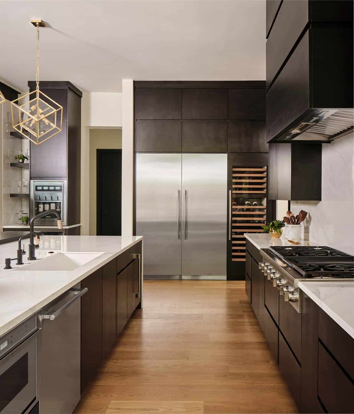 Kitchen with built-in stainless refrigerator, wine fridge, and dark wood cabinetry