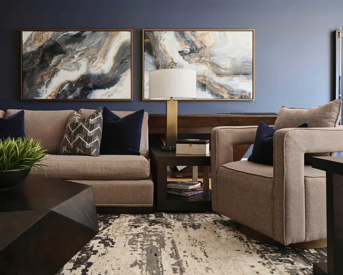 Close-up of taupe sofa seating with navy pillows and framed marble abstract paintings