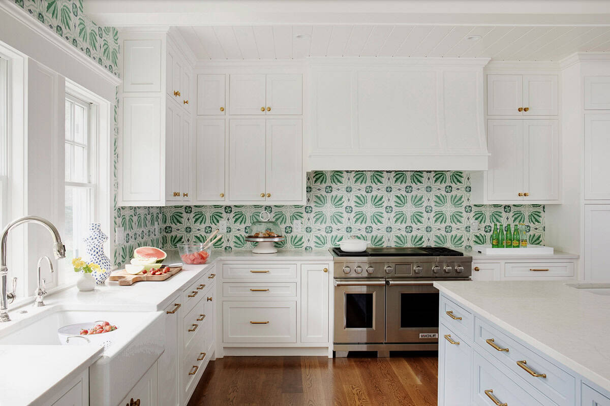 Range wall with green patterned tile and stainless steel appliances