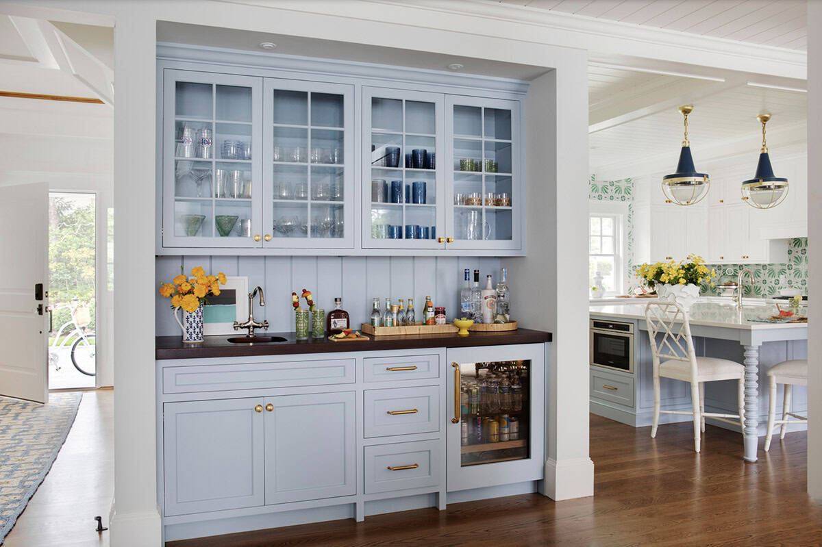Butler's pantry with light blue cabinetry and glass front uppers