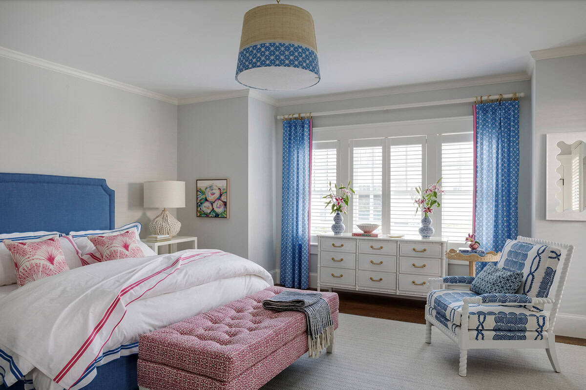 Coastal bedroom with blue upholstered bed and pink patterned bench
