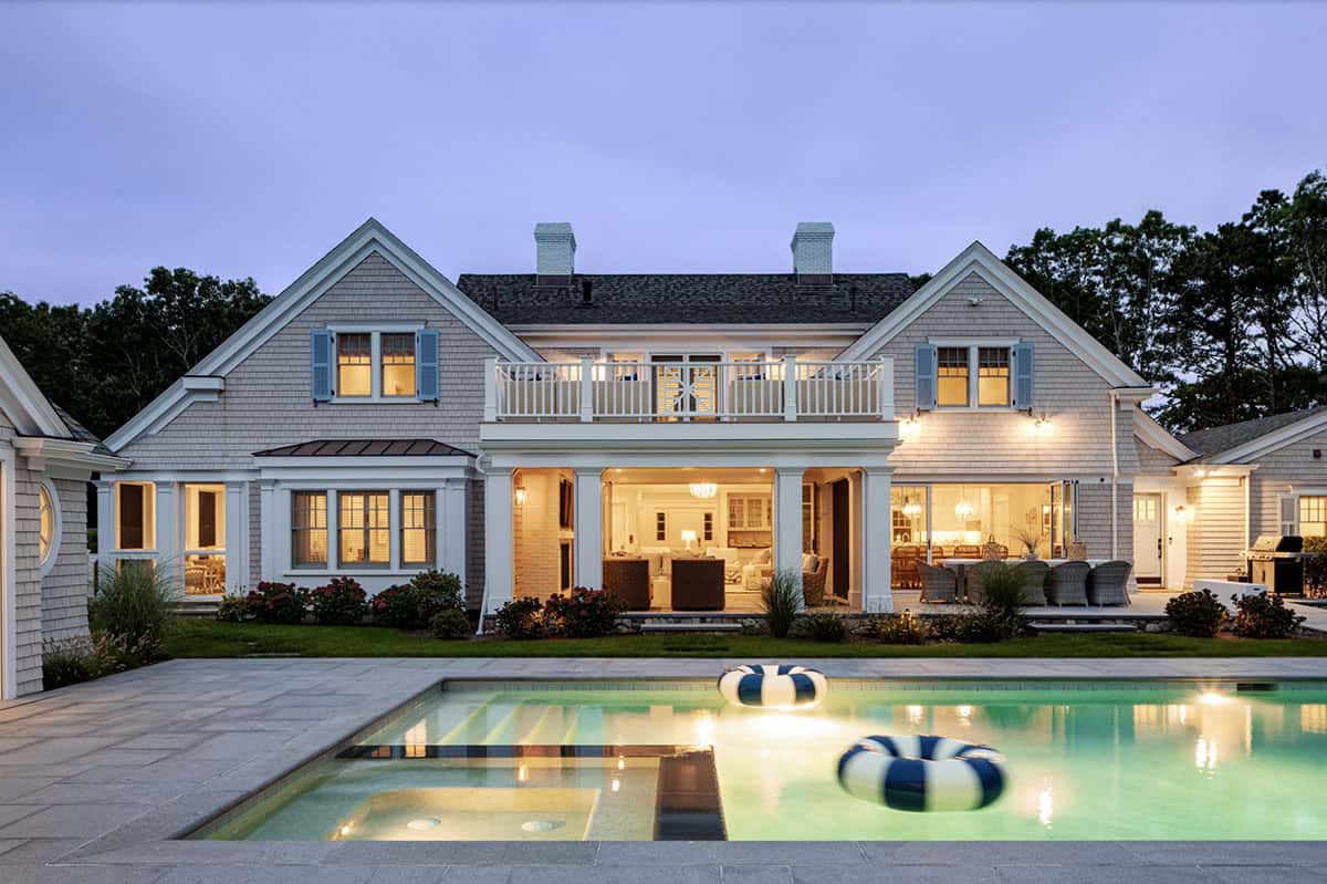 Rear facade at dusk overlooking pool with striped floats
