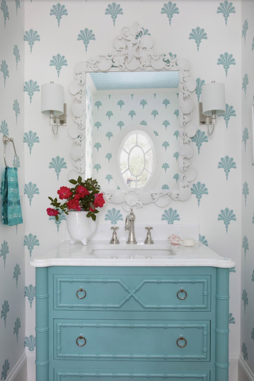 Powder room with turquoise vanity and shell patterned wallpaper