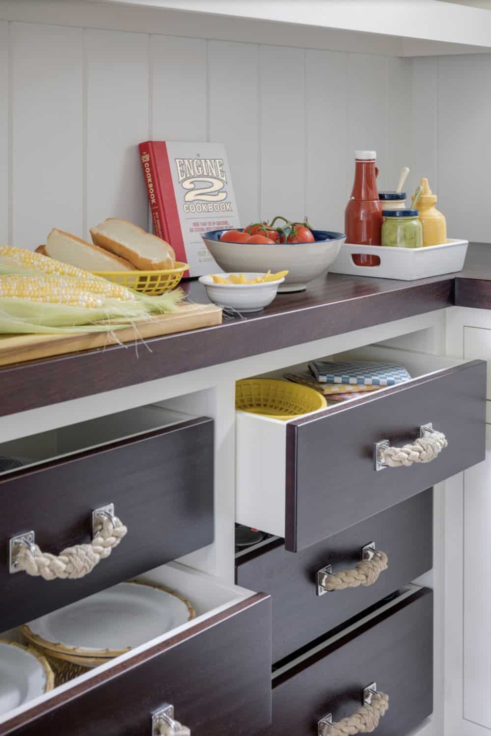 Open drawer detail showing rope pulls and stacked dinnerware