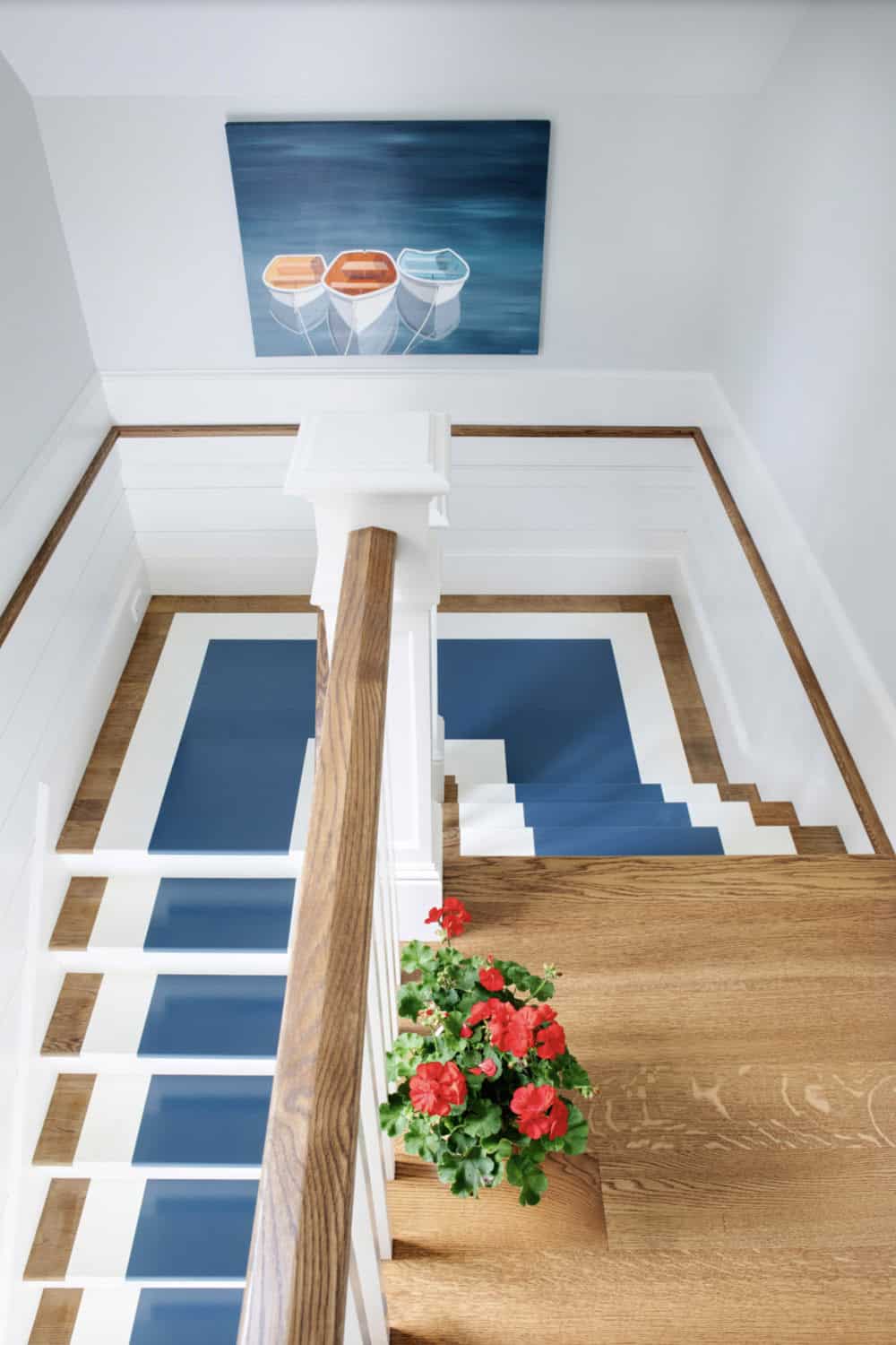 Stairway view looking down at painted blue stair runner
