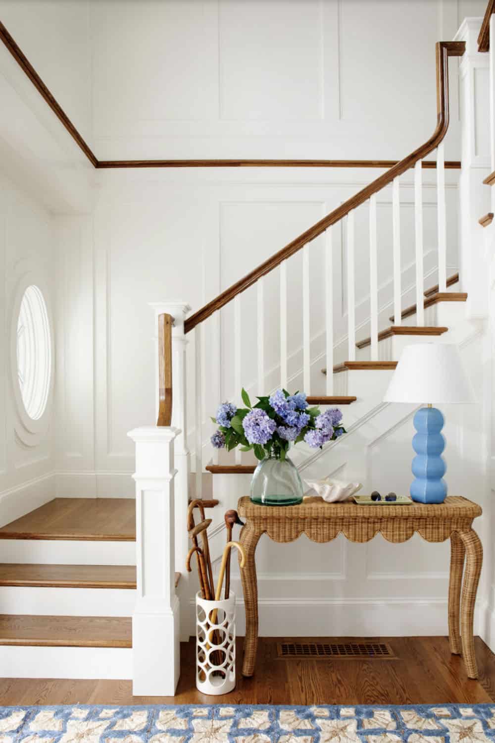 Entry landing with wicker console table and oval window