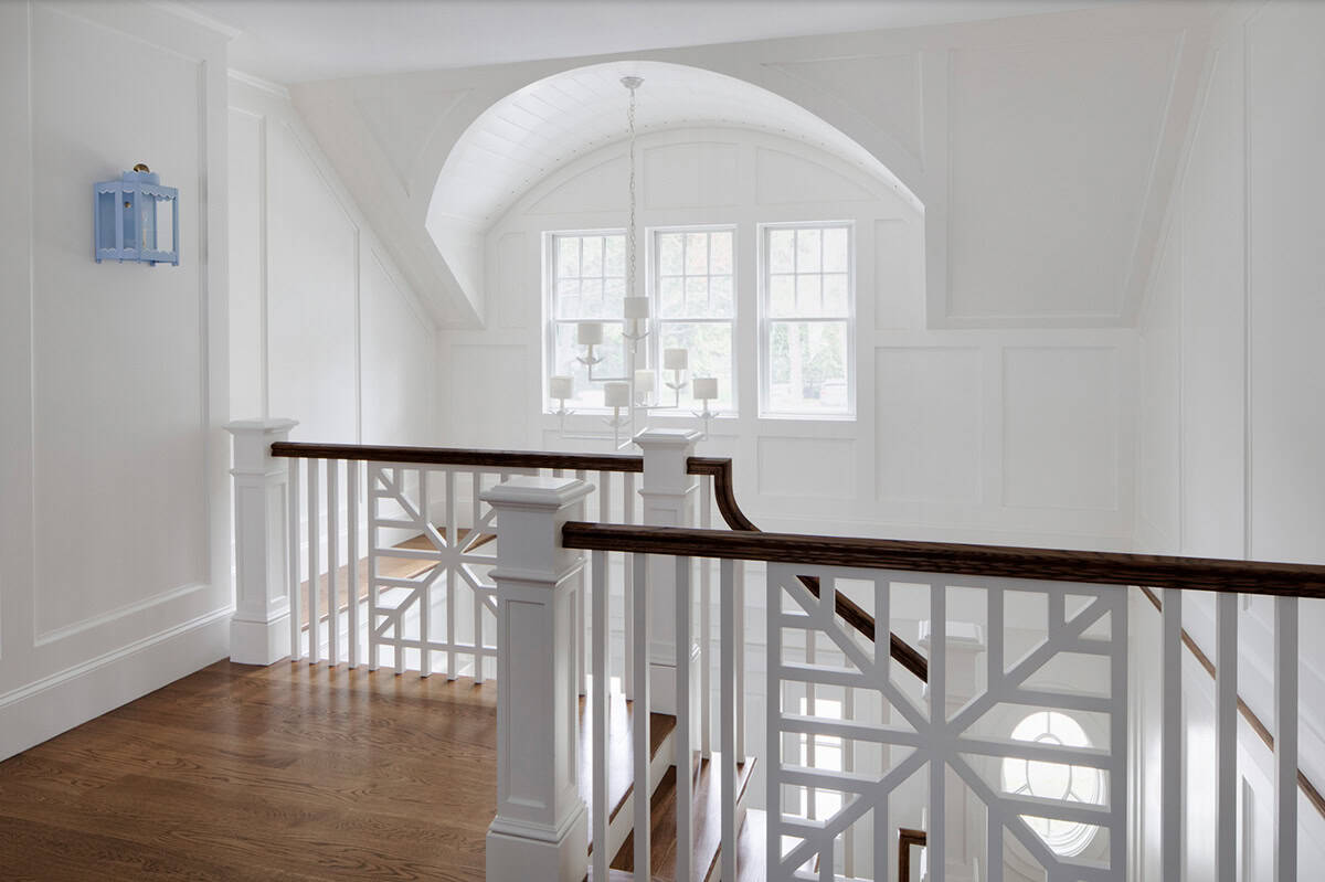 Upper hallway with fretwork railing and arched window nook