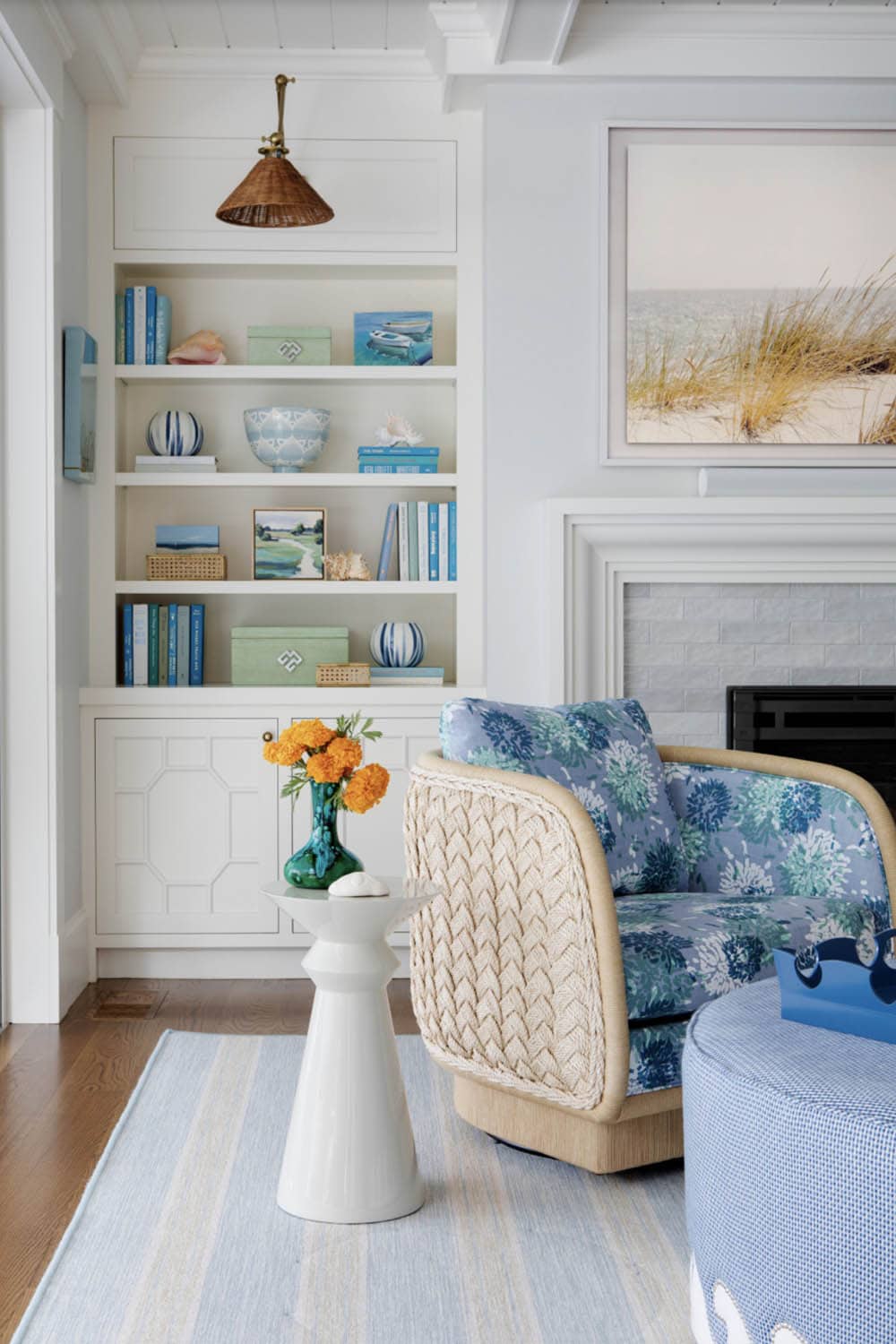 Reading nook with floral swivel chair beside built in bookshelves