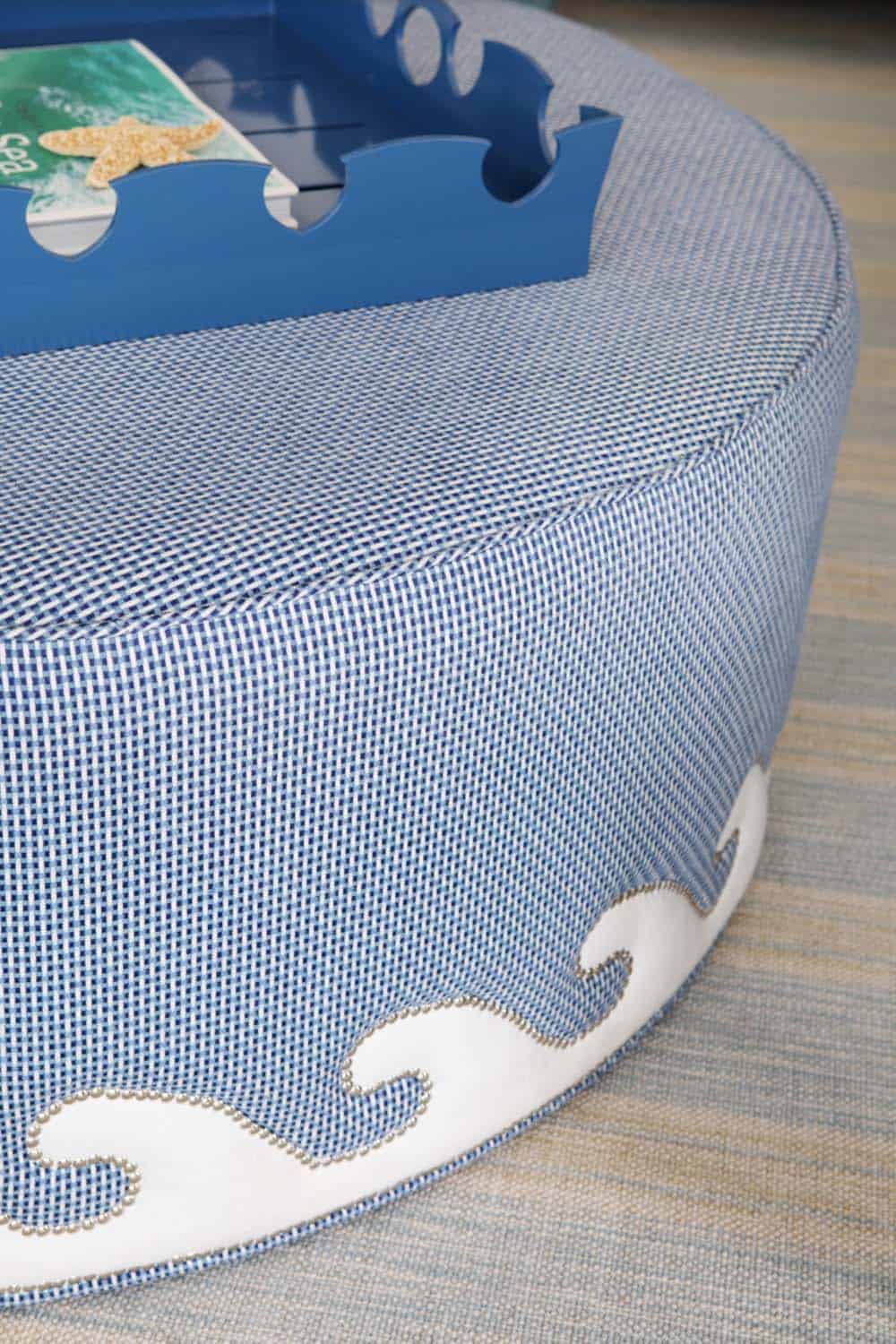 Wave detail on blue ottoman with nailhead trim accent