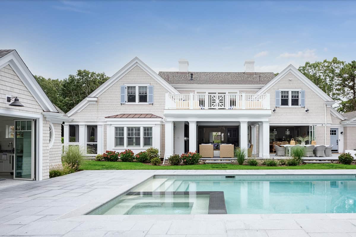 Daytime rear facade with covered porch overlooking pool and spa