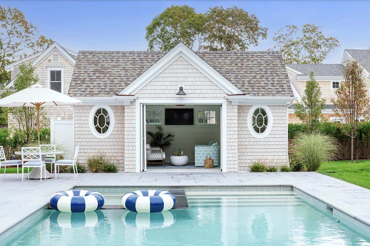 Poolside cabana with striped floats and open bifold doors