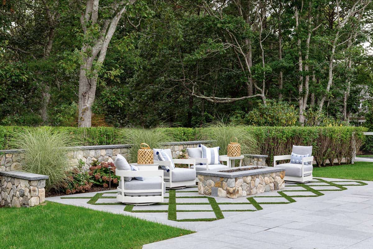 Stone fire pit lounge area surrounded by ornamental grasses