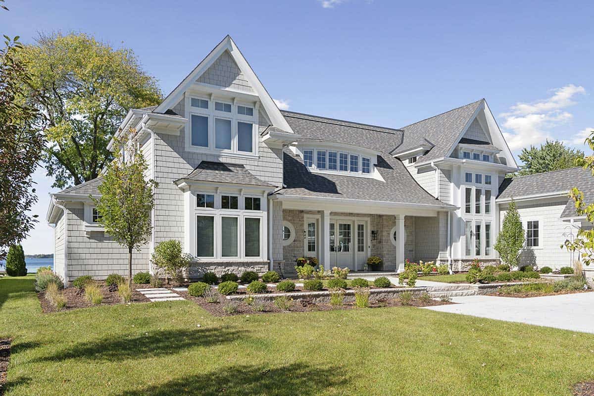 Nantucket-style shingle lake house exterior with multiple gables and stone accents