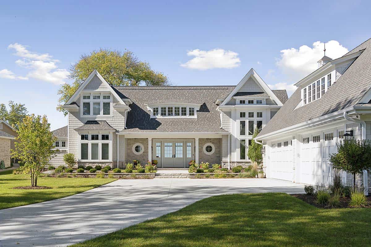 Front view of shingle-style home with circular windows and attached garage