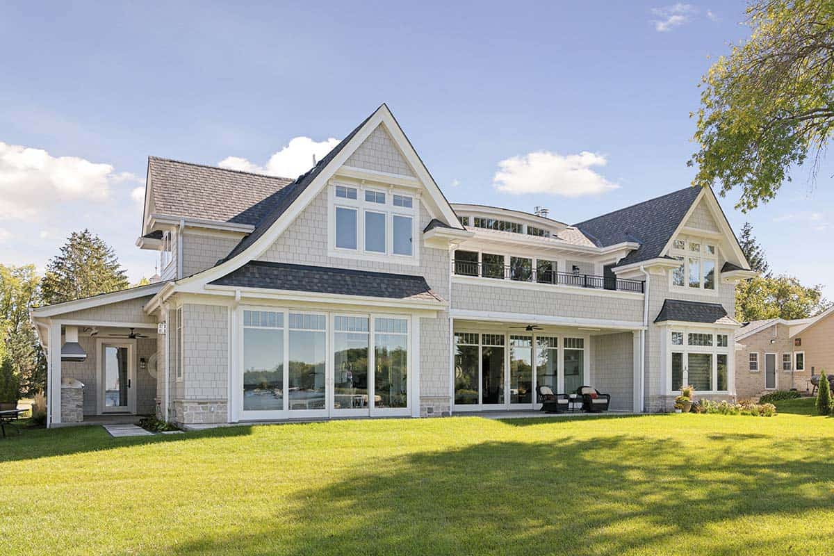 Lake-facing rear exterior with balcony and wall of glass doors