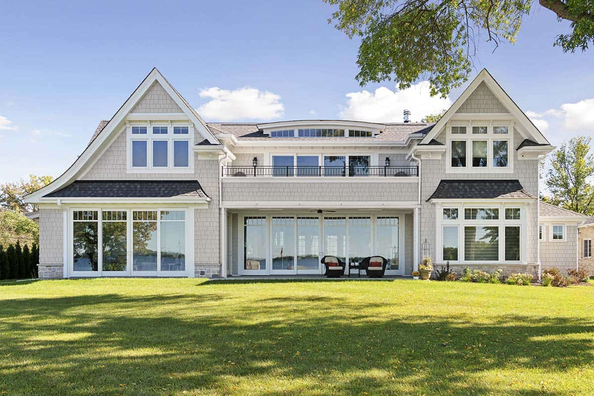 Rear view of home overlooking lawn with folding glass patio doors