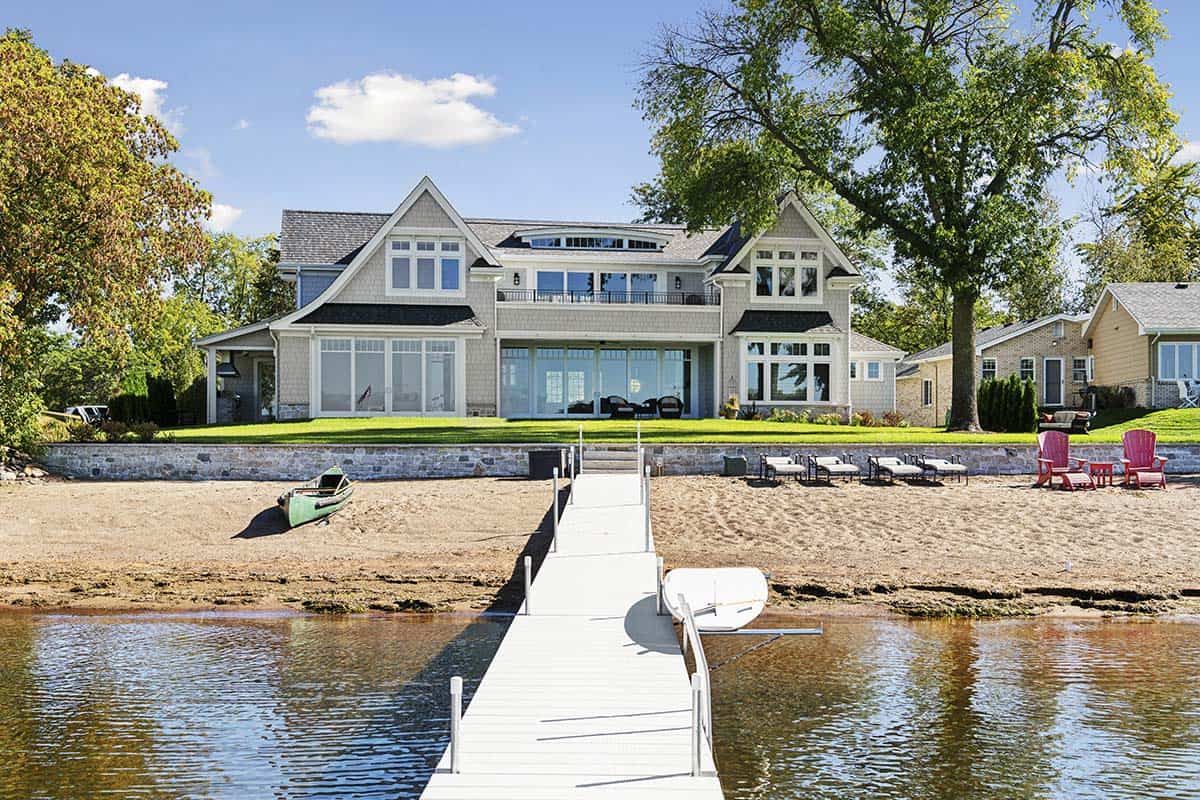 Lake house viewed from dock with sandy beach and canoe