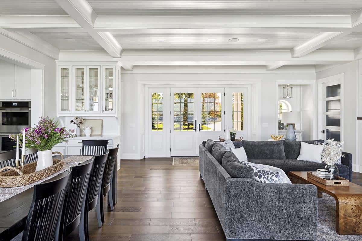 Open living and dining area with coffered ceiling and French doors