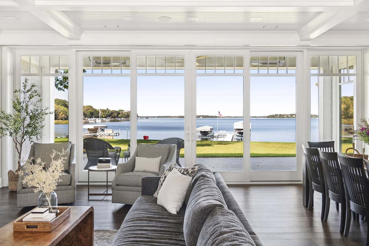 Sunroom seating area with lake and dock views through glass doors