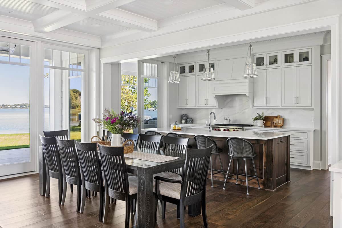 Dining table with lake views and wood-toned kitchen island
