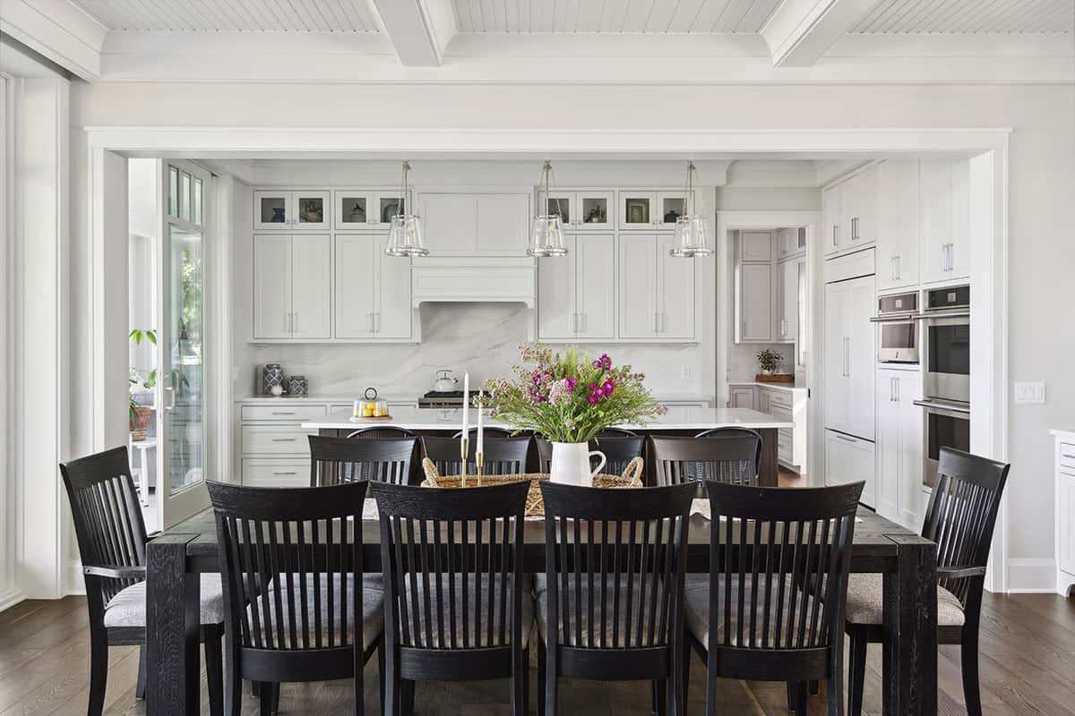 Dining table facing kitchen with glass pendant lighting