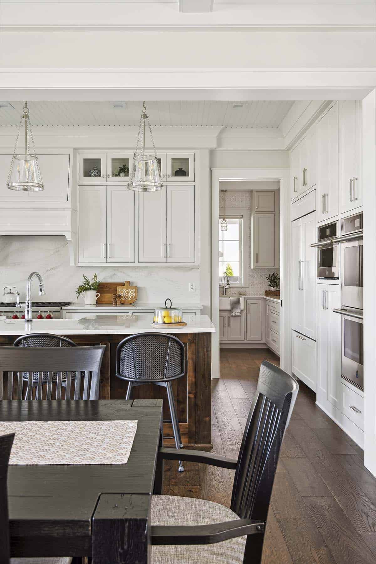 Kitchen island with cane counter stools and hallway to butler's pantry