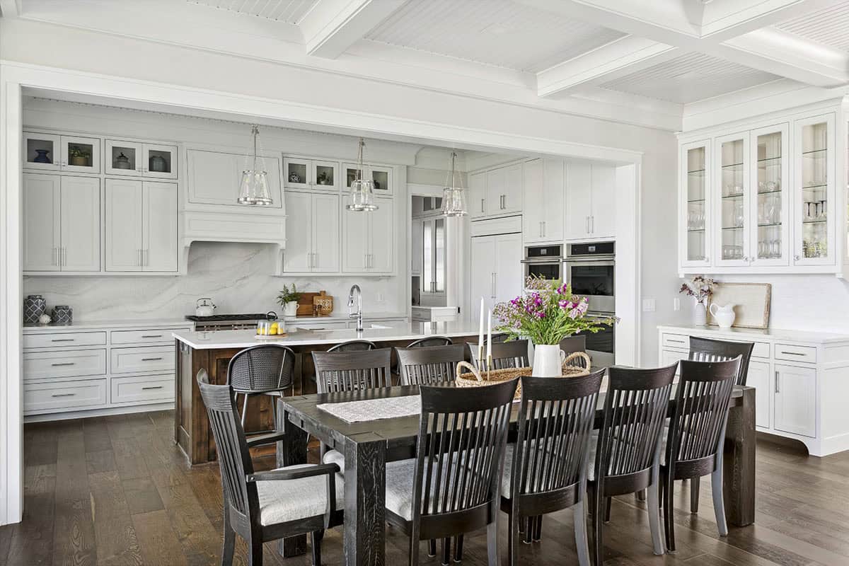 Wide view of kitchen and dining room with glass-front cabinetry