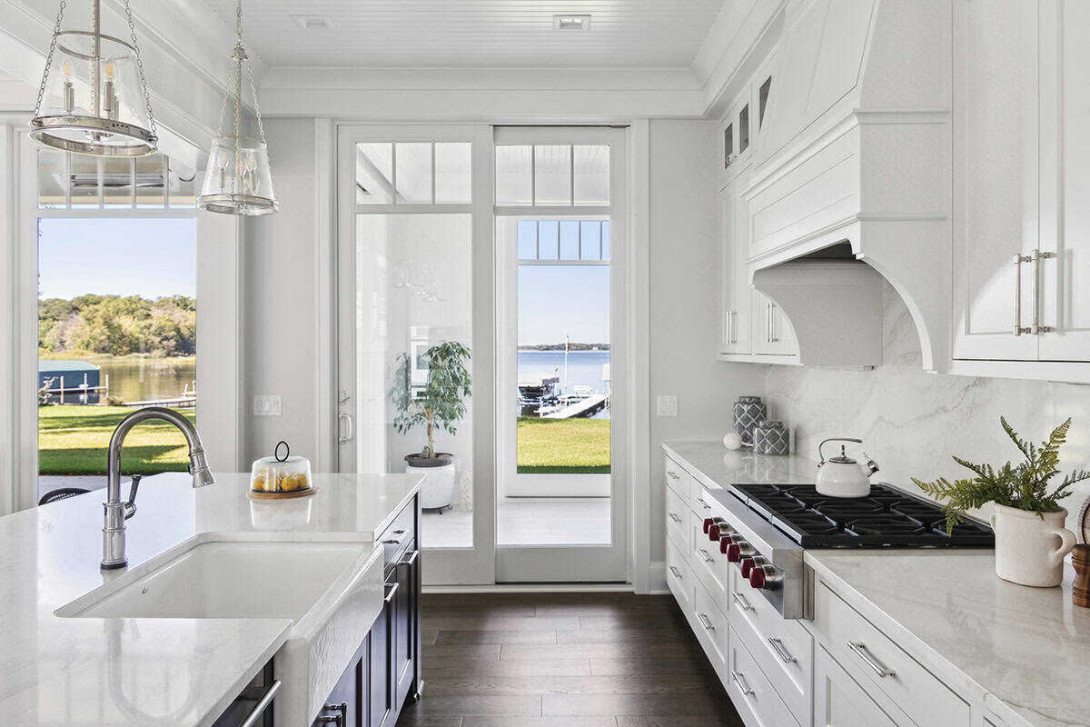 Galley kitchen with gas range and glass doors to lake patio
