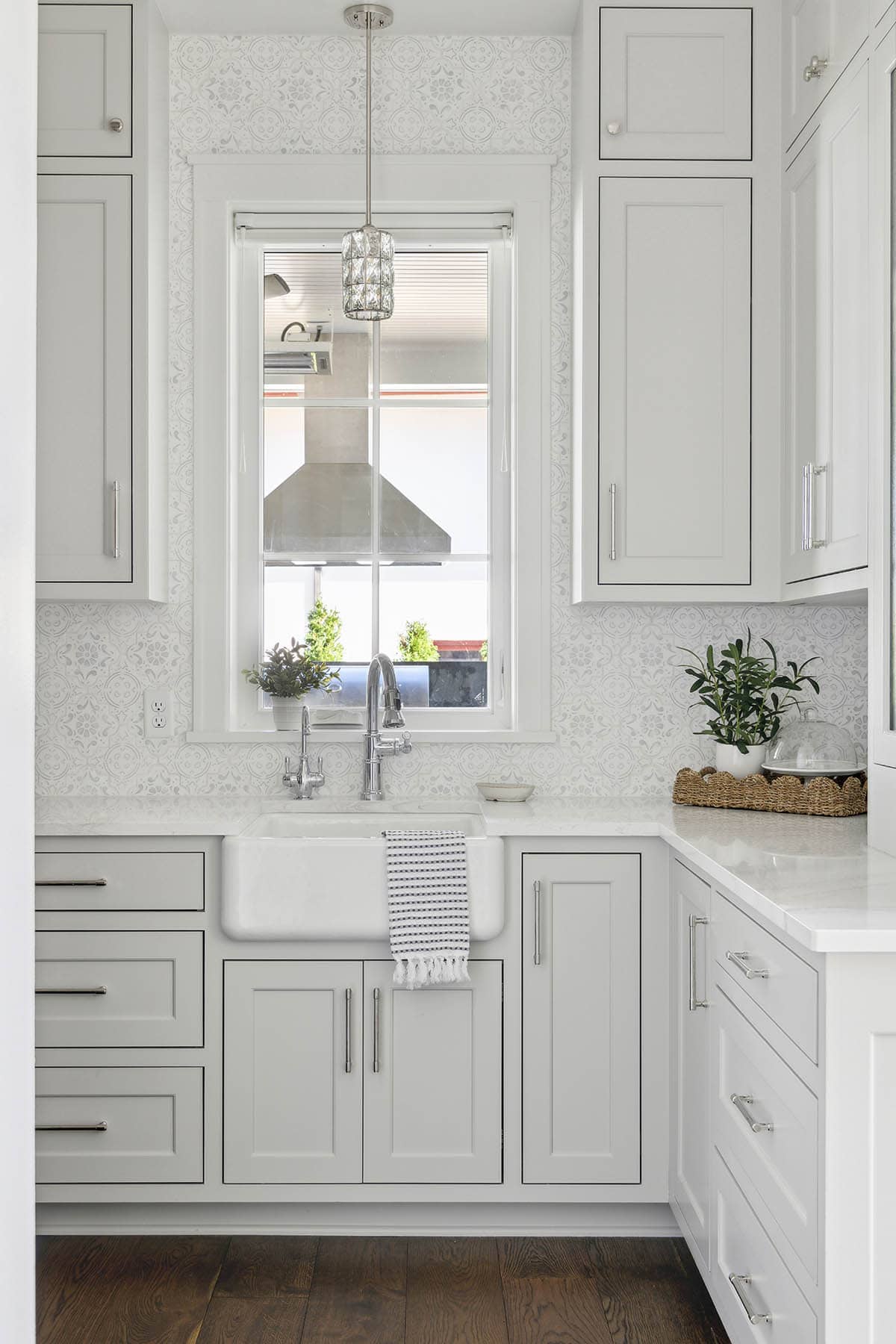 Farmhouse sink with patterned backsplash and window view