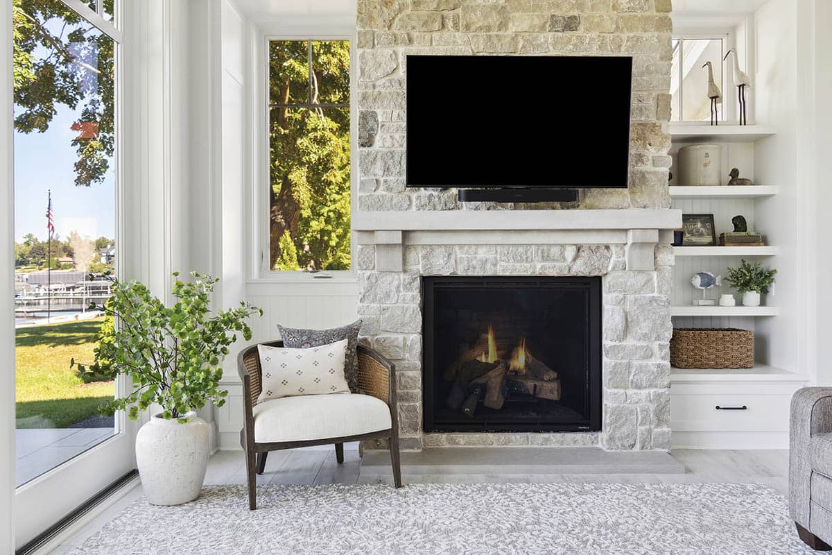 Stone fireplace with mounted TV and built-in shelving