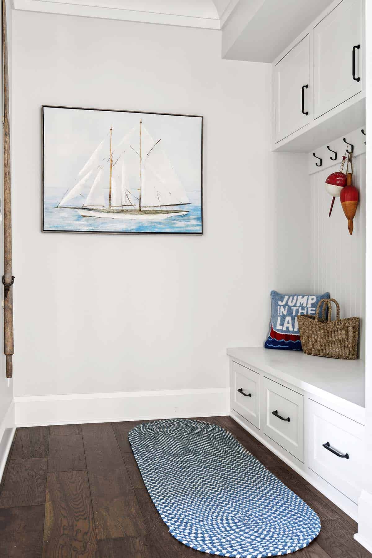 Mudroom bench with sailboat art and nautical throw pillow