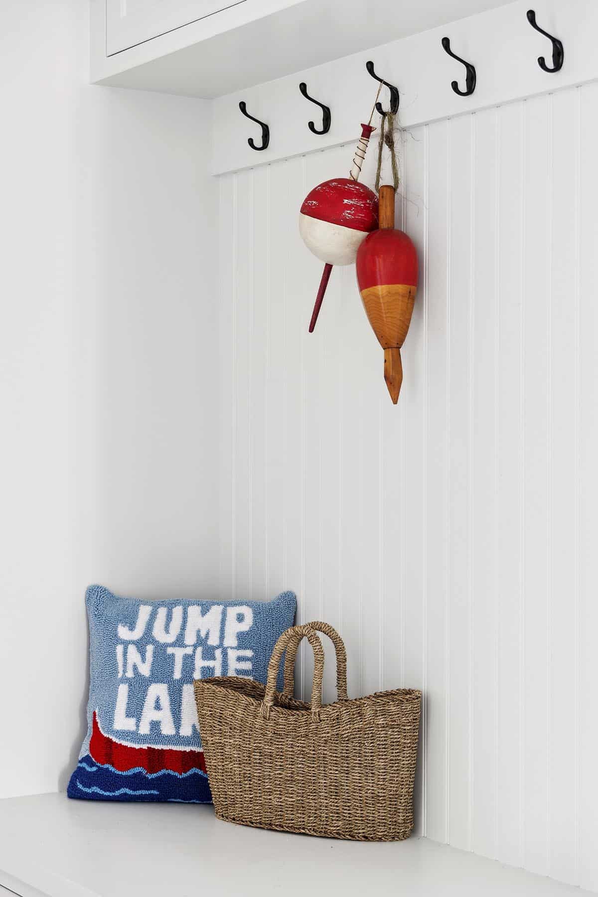Mudroom hooks with vintage wooden fishing buoys and woven tote