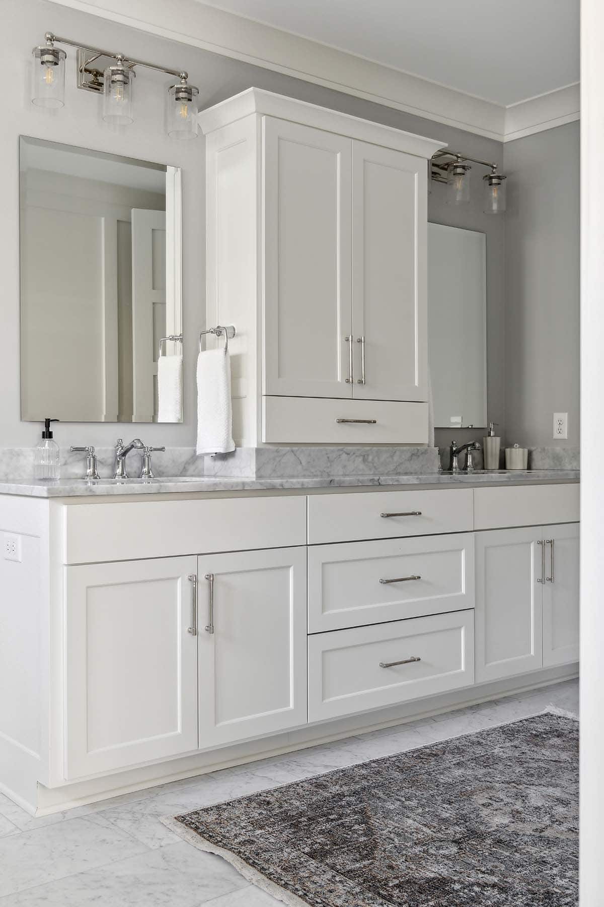 Double vanity with marble countertop and linen cabinet