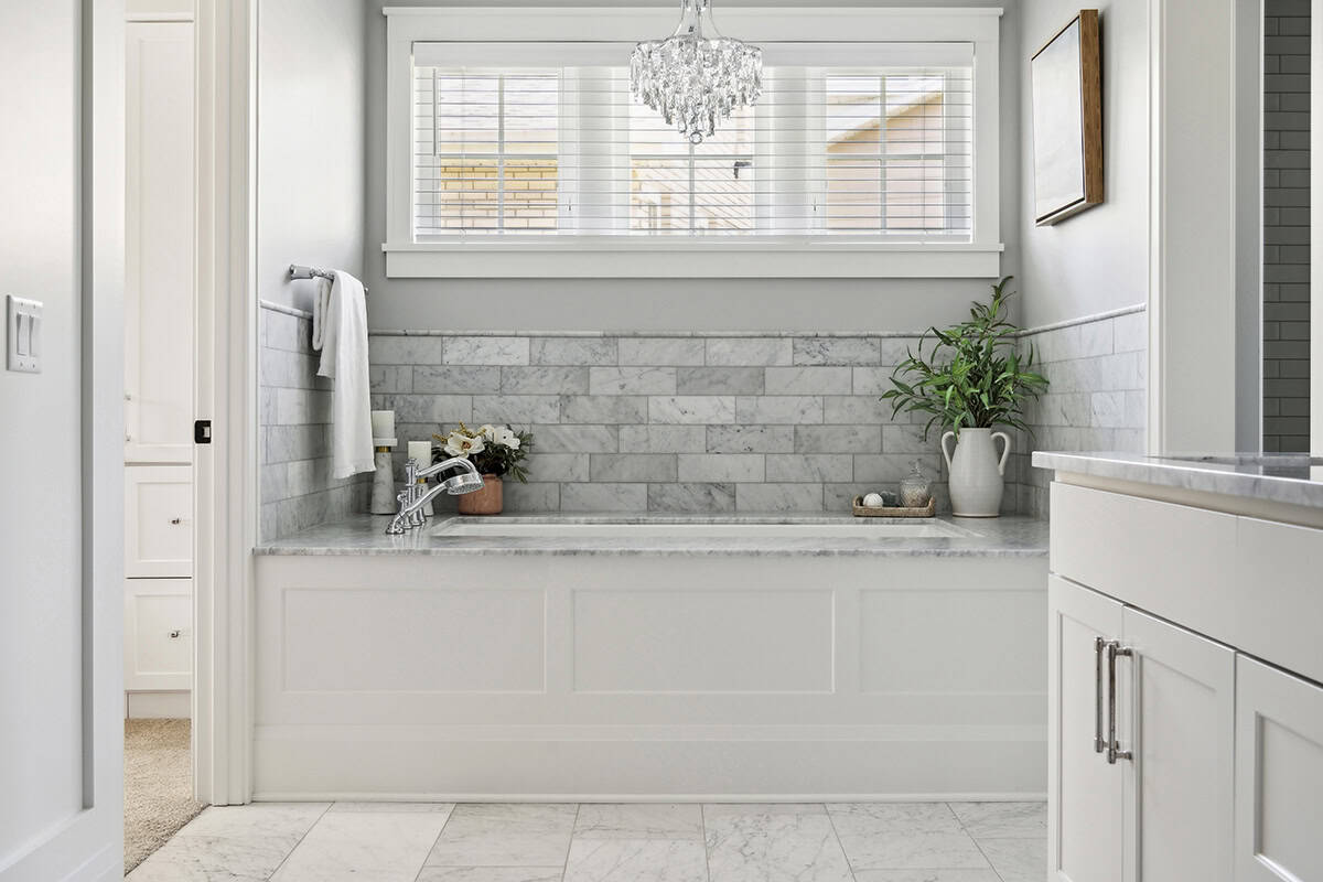 Soaking tub with marble surround under crystal chandelier