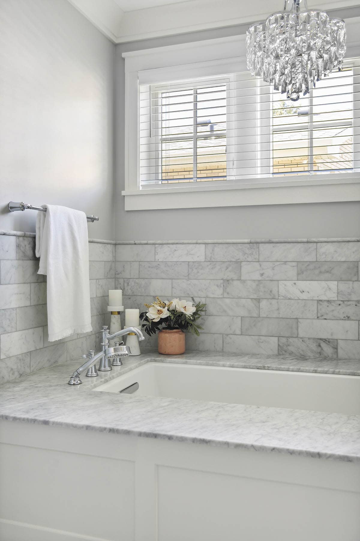 Tub deck with marble tile and chrome fixtures