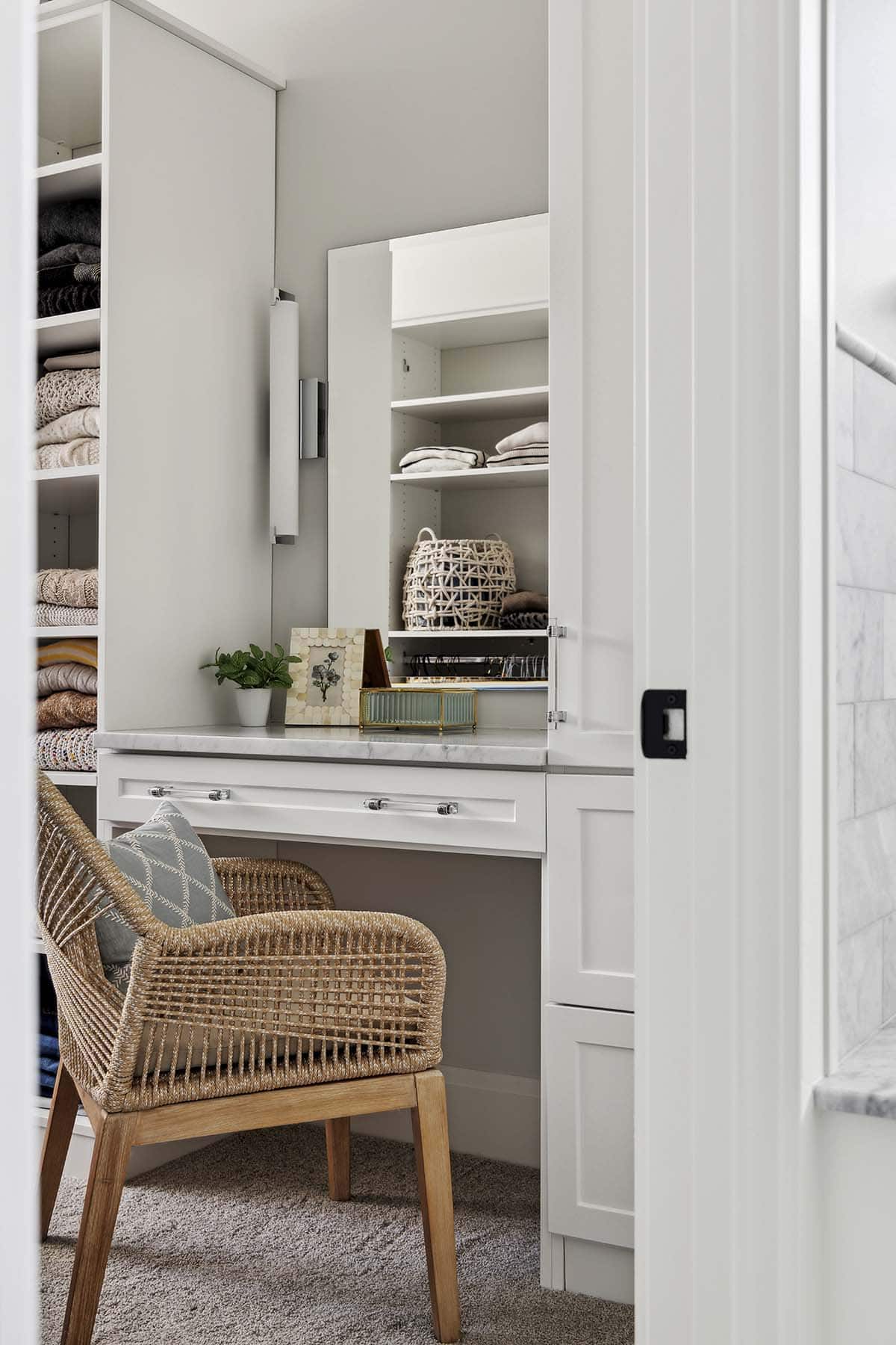 Walk-in closet with built-in vanity desk and woven chair