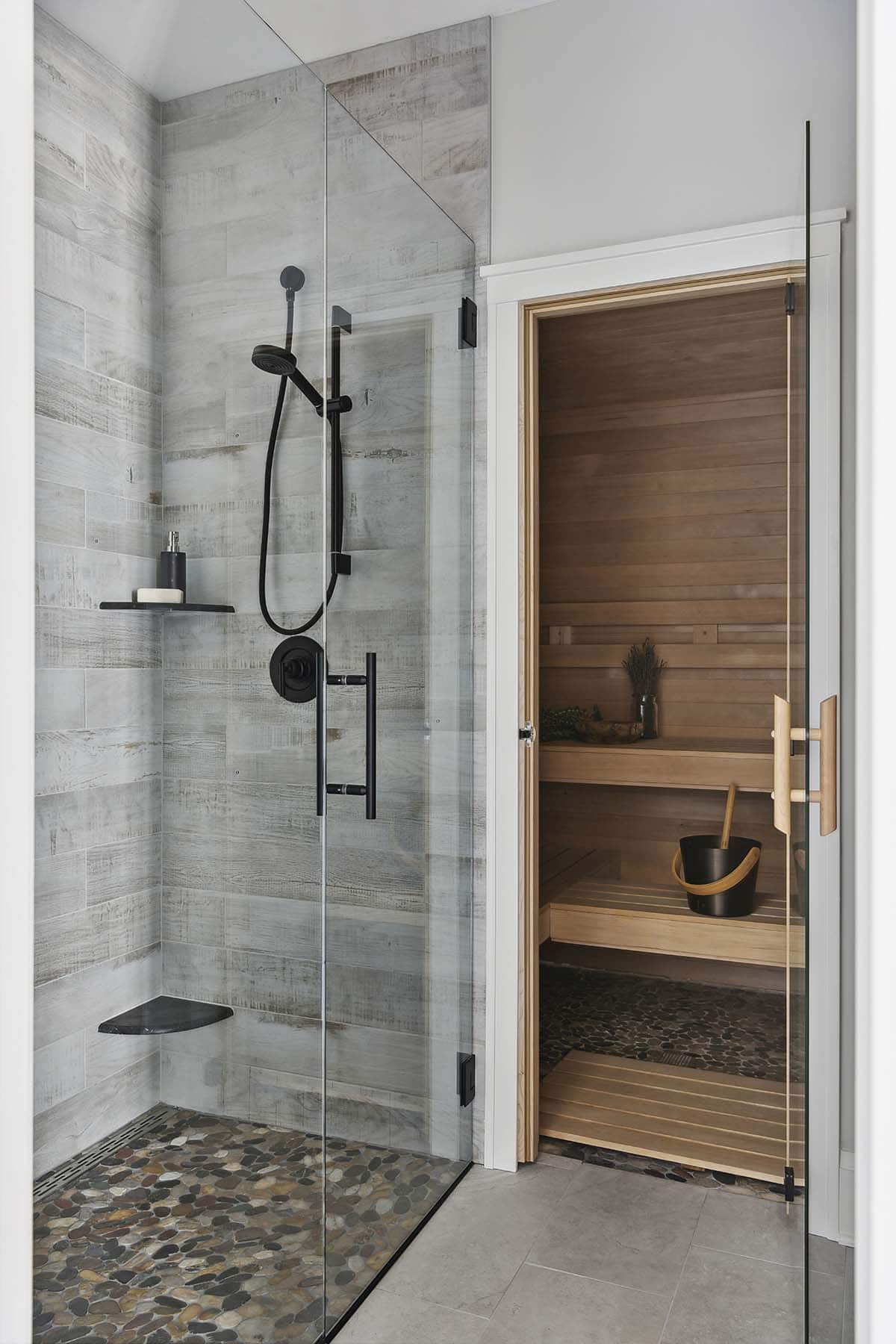 Glass shower with wood-look tile beside cedar sauna doorway