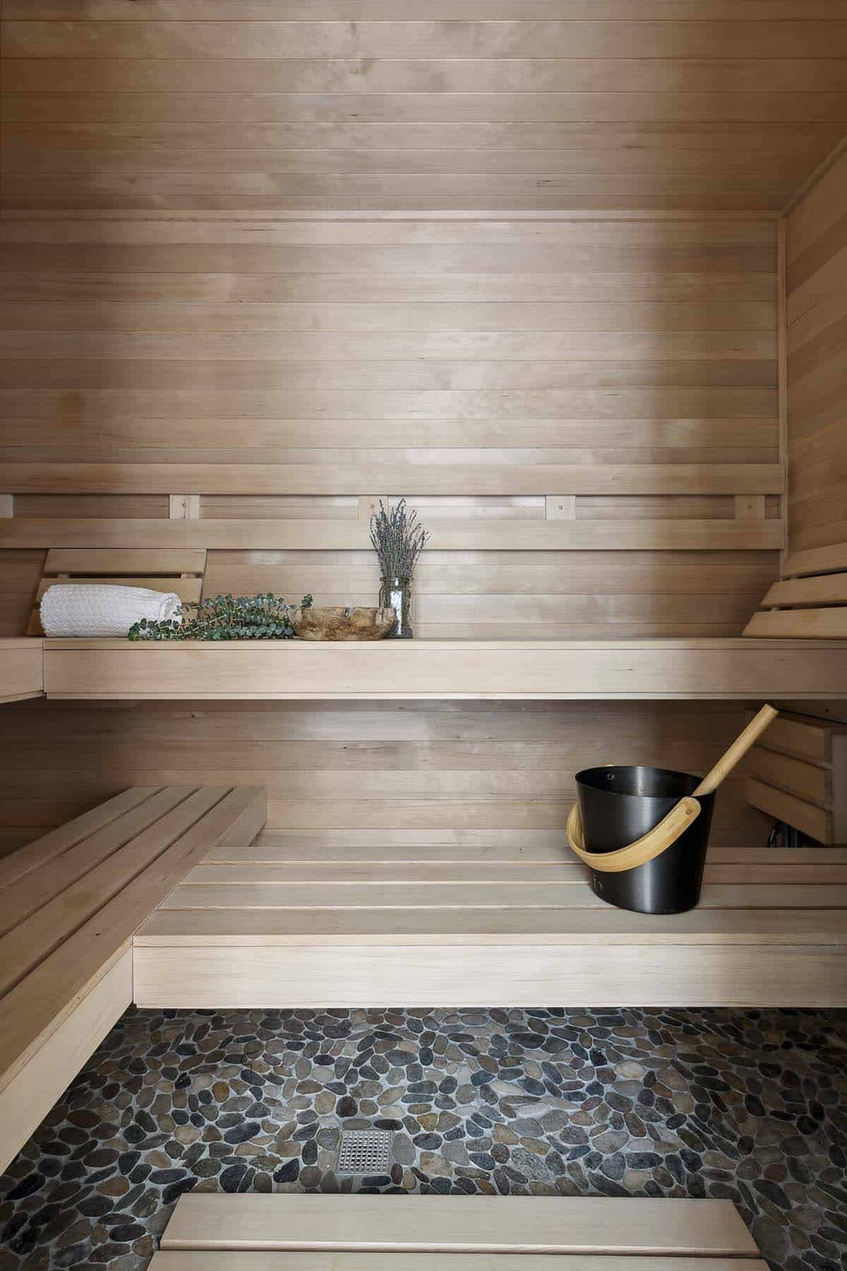 Cedar sauna benches with towels, eucalyptus, and bucket