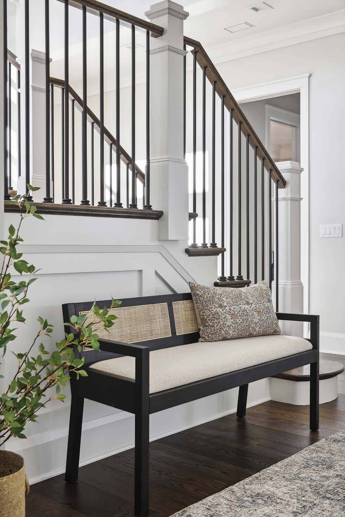Staircase detail with cane bench and potted plant below