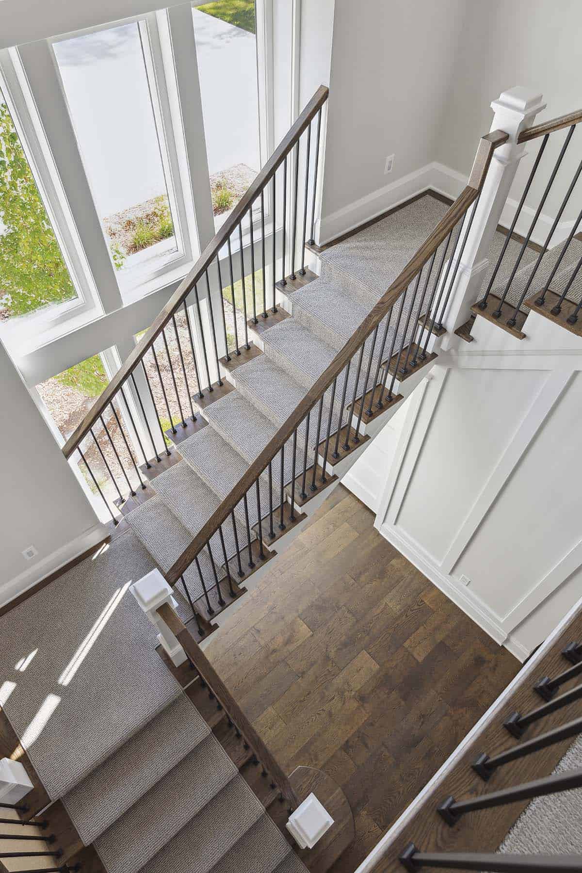 Overhead view of carpeted staircase with wood floors below