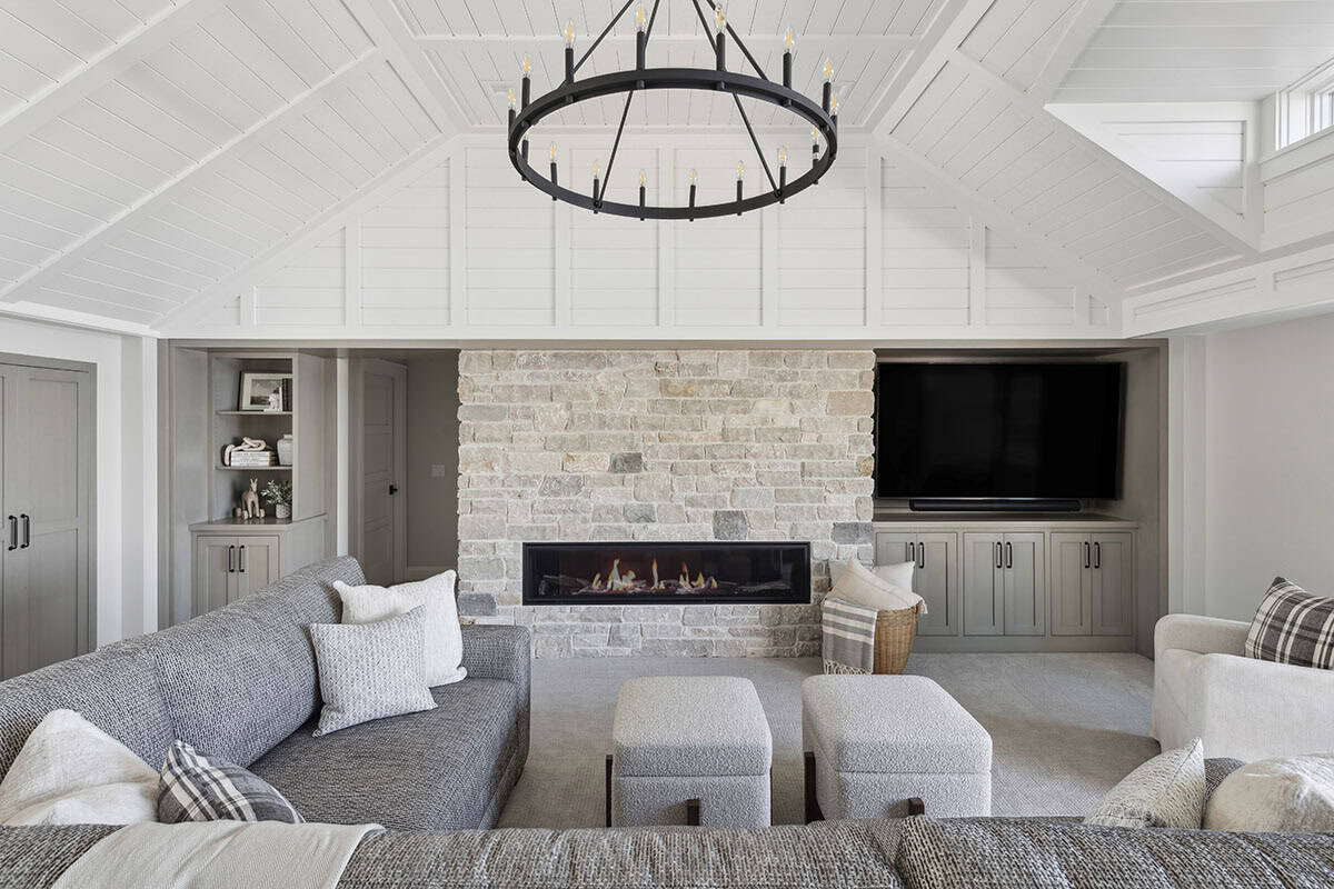 Family room seating area with stone fireplace and wheel chandelier